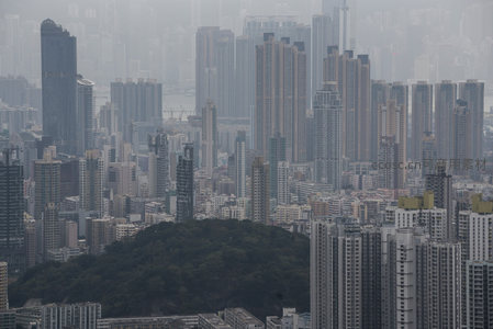 雾霭中的香港密集高楼群与绿意山丘航拍景观