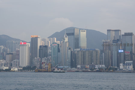 维港对岸金融核心区特写，标志性摩天楼群与品牌广告林立