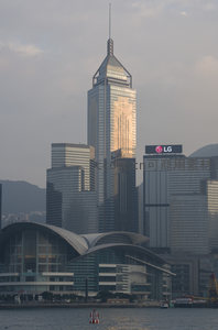 夕阳余晖映照中银大厦玻璃幕墙，香港会议展览中心前港湾