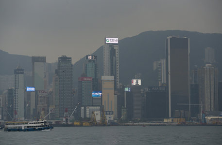 雾霭中的维港天际线，现代高楼与远山相映成趣