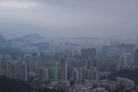 阴云笼罩下的香港密集城市景观与远山轮廓