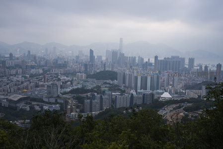 山顶俯瞰雾霭香港全景，楼宇森林与青山相映