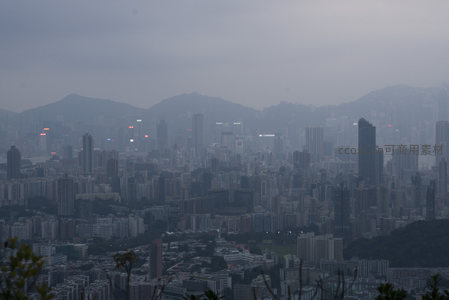 薄雾笼罩下的维港两岸，密集楼宇群在灰蓝调中延伸