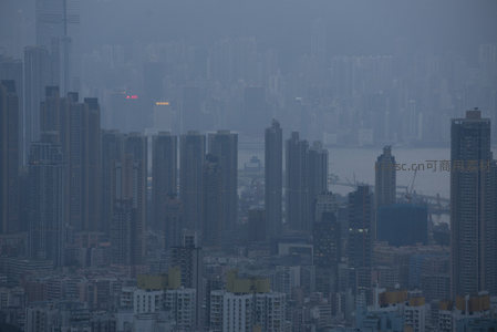 维港侧影隐于雾霭，密集住宅与商业楼群构成城市肌理