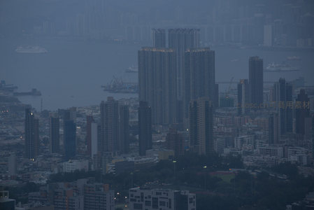 雾霭笼罩的港岛高层住宅群，海面船只穿行，城市静谧而深邃