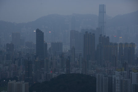 香港中环摩天楼群剪影映衬山脊线，雾中霓虹闪烁，都市壮阔而神秘