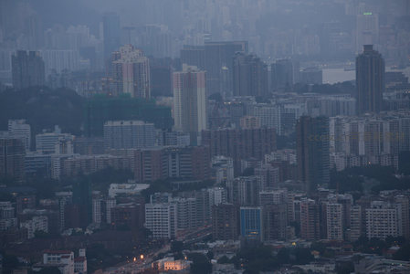 暮色低垂，香港住宅区在薄雾中层叠延伸，灯火渐次点亮