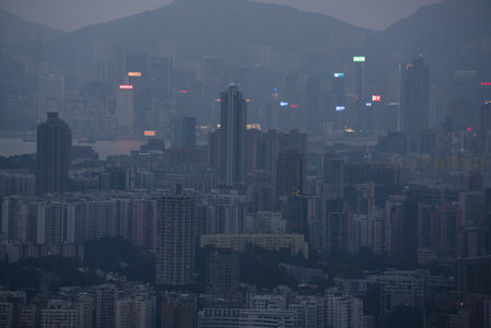 夜幕初临，港岛核心商圈霓虹初闪，雾中楼宇若隐若现