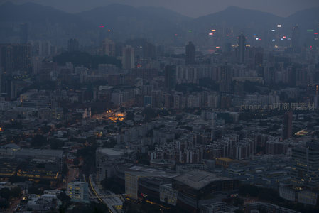 香港低密度城区夜幕初降，街灯蜿蜒，山体环抱，楼宇错落有致