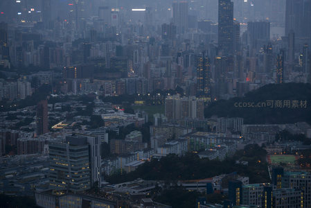 高处俯瞰港岛密集住宅区，绿丘点缀其间，夜幕低垂光影朦胧