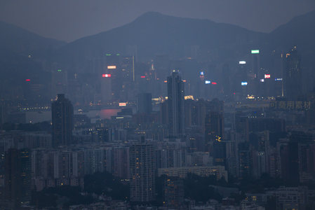 远山背景下香港CBD夜景，霓虹招牌闪烁，城市脉搏在薄雾中跃动