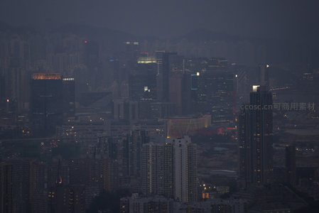 迷雾笼罩下的维港两岸，霓虹微光穿透灰蓝暮霭，城市脉搏悄然苏醒