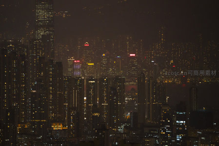 雾霭中的香港天际线夜景，COSCO等企业标识在楼顶熠熠生辉