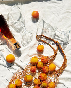 网袋杏子与空酒杯的静物诗：阳光穿透玻璃的夏日私语