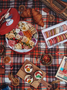 格子野餐布上的法式甜点与鲜花礼盒静物