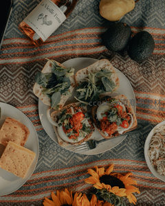 野餐布上的精致美食与向日葵，玫瑰酒与牛油果点缀惬意午后
