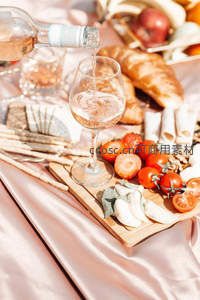 玫瑰酒倾倒入高脚杯的动态瞬间与野餐美食组合