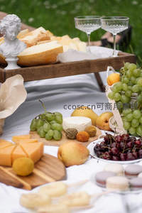 丰盛奶酪拼盘野餐：葡萄、樱桃、梨与古典雕塑点缀的法式风情