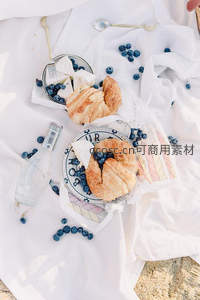 俯拍白布上的法式早餐：羊角面包、蓝莓与奶酪精致摆盘