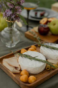 近景野餐台细节：奶酪、水果与淡紫色花束营造浪漫氛围