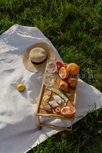 草地上俯拍野餐场景：草帽、葡萄柚与奶酪构成的静谧午后构图