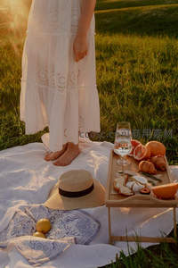 夕阳下白色蕾丝长裙女子草地野餐静谧时光