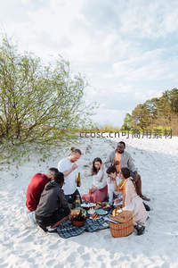 多元族裔朋友沙滩野餐欢聚，共享美食与阳光时光