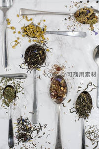 多味茶勺平铺：干花茶叶与金属勺的精致组合