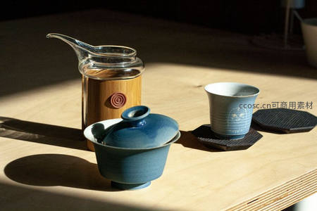 阳光洒落的青瓷盖碗与竹制茶壶静物特写
