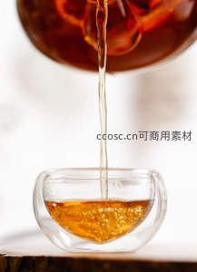 透明双层玻璃杯承接倾泻茶流，光影流动如琥珀