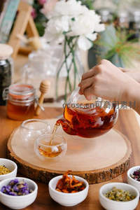 手冲花茶特写：琥珀色茶汤缓缓注入双层玻璃杯中