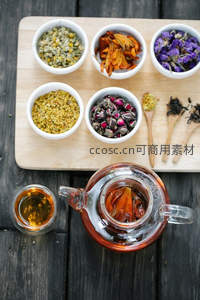 茶具全景俯拍：玻璃茶壶内含金盏花，六碗干花环绕布局