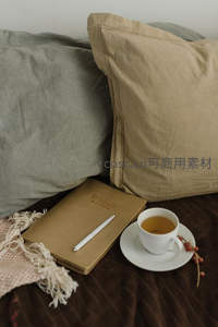 床头静谧茶时光：米色亚麻枕、手写笔记本与一杯清茶相伴