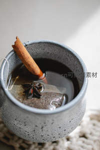 粗陶杯中热饮特写：肉桂棒与八角点缀暖意冬日茶饮