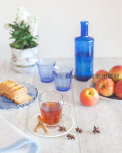 清新茶桌布景：玻璃杯红茶配苹果、肉桂与蓝瓶水景致