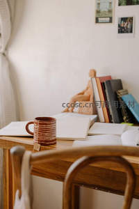 书桌静物叙事：陶杯、手稿与雕塑小像构成的文艺工作台