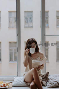 窗边晨读时光：女子手捧咖啡书本，享受宁静早餐时刻
