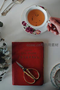 复古红皮书与花瓷茶杯静物组合，文艺气息浓郁
