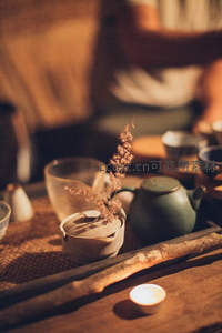 暖光茶席上的干草与陶器静物特写