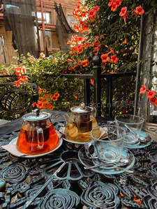庭院铁艺桌上双壶茶具与凌霄花景致