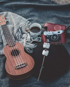 复古尤克里里、胶片相机与热可可静物组合，营造怀旧露营氛围