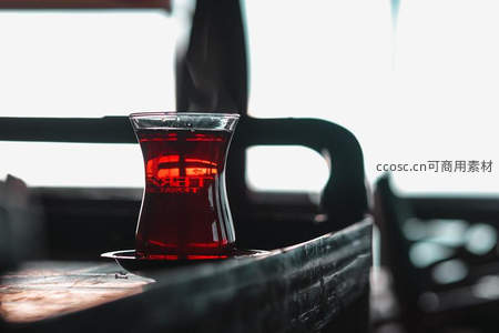 复古车厢内一盏热茶，红润茶汤与木质托盘构成怀旧光影