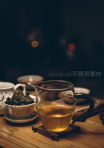 琥珀茶汤盈满玻璃公道杯，余温氤氲映衬古朴茶席