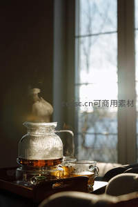 玻璃茶壶蒸腾热气，窗边暖光映照冬日暖心茶叙