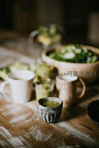 木质桌面上的抹茶饮品与陶碗静物特写