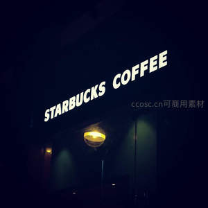 夜色中星巴克招牌发光，暖黄吊灯映衬静谧咖啡馆入口