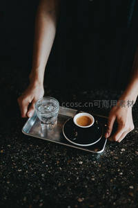侍者双手托银盘递送意式浓缩与冰水，黑瓷杯碟搭配简约高级感