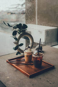 雨窗边木盘双饮：奶油冷萃与冰美式，绿植点缀诗意午后