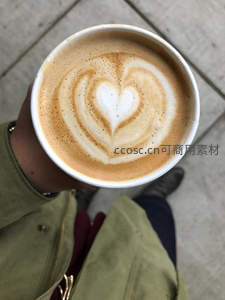 手捧爱心拉花咖啡，俯拍街角温馨瞬间