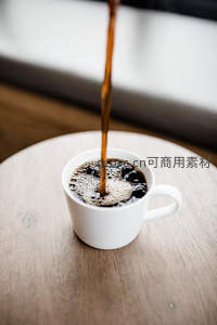 热咖啡注入白瓷杯瞬间，泡沫细腻升腾，木质桌面映衬温馨晨光